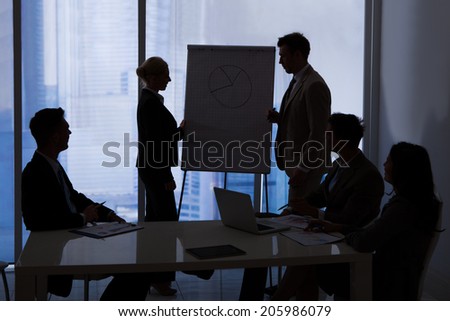 Silhouette of business people having a discussion in conference room