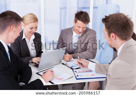 Group of young business people discussing at table in office