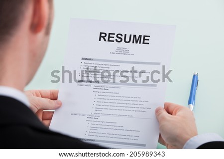 Cropped image of businessman reading resume at office desk