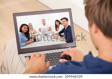 Cropped image of man attending conference meeting on laptop at home
