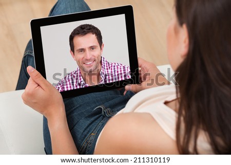 High angle view of young woman video chatting with man at home