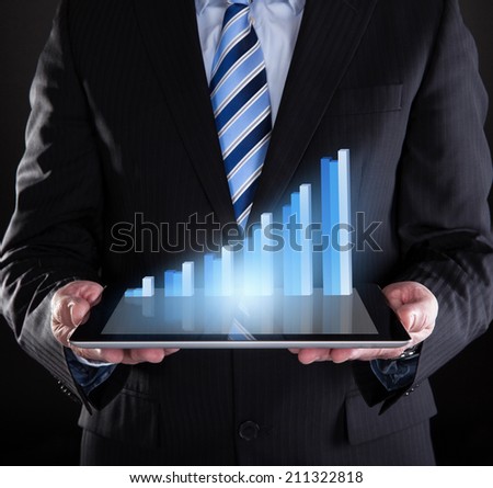 Midsection of businessman holding digital tablet with graph representing growth