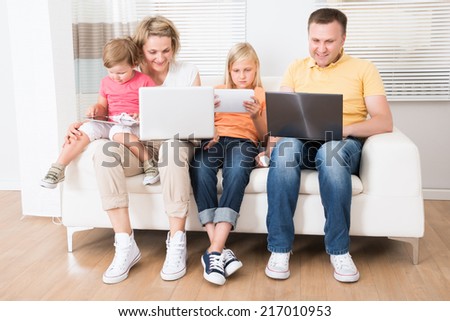 Family Using Tablets and Computers At Home