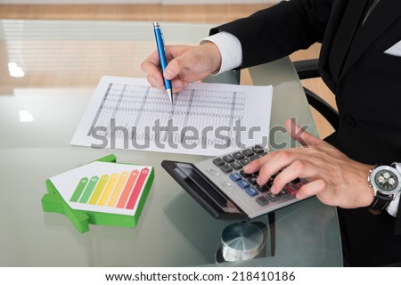Cropped image of businessman calculating energy efficiency rate in office