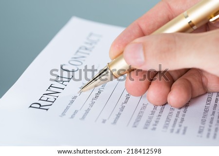 Hand filling rental contract document. Closeup shot