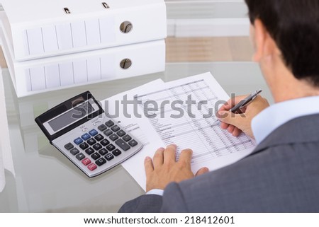 Business man accountant calculating invoices in office