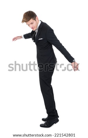Full length of young businessman about to fall over white background