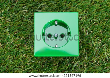 Wall socket on grass. Environmental friendly energy concept