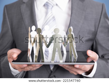 Businessman holding paper people on tablet. Closeup shot