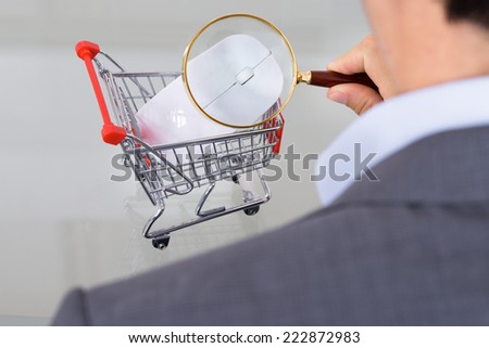 Businessman inspecting shopping cart. Over the shoulder view