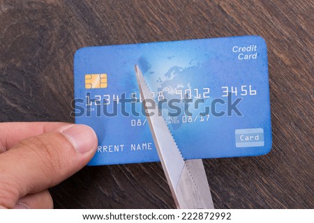 Scissors cutting old credit card. Closeup shot