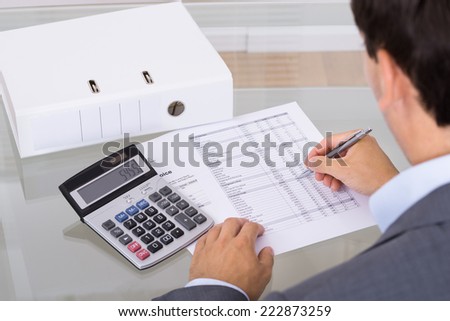 Accountant calculating finances. Over the shoulder view