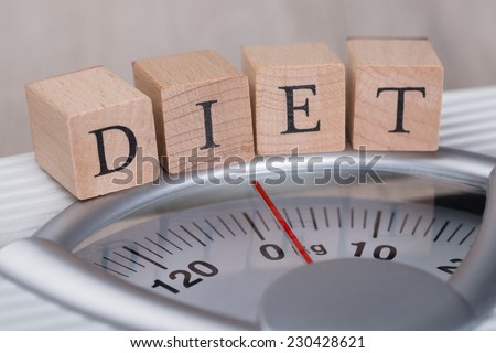 Closeup of Diet wooden blocks arranged on weight scale
