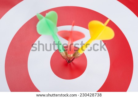 Closeup of darts on concentric red and white target