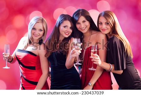 Portrait of happy women holding champagne flutes at nightclub