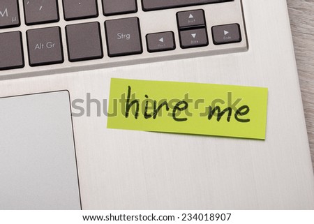 Closeup of Hire Me sticky note message on laptop