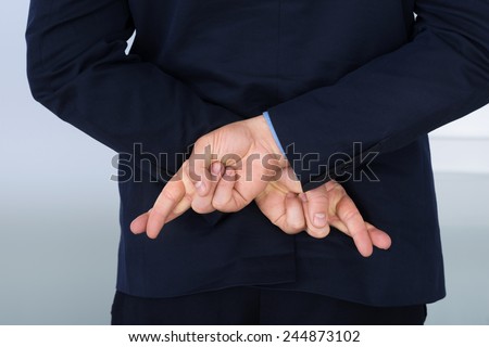 Businessman Standing With Crossed Finger Behind His Back