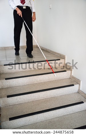 Blind Man Moving Down On Stairway Holding Stick