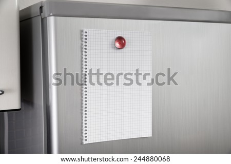 Close-up Of Blank Paper Posted On Modern Refrigerator Door
