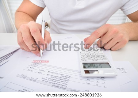Man Calculating Past Due Statement Using Calculator