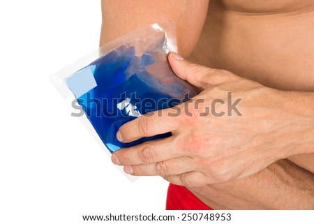 Close-up Of Hand With Ice Gel Pack On Elbow Over White Background
