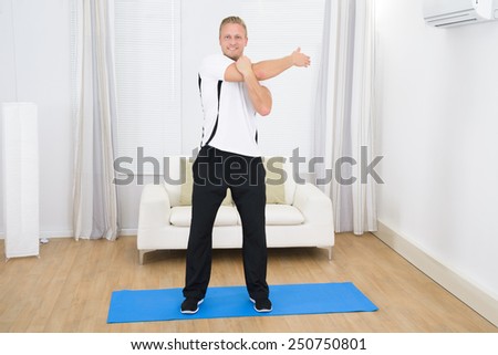Portrait Of Smiling Man Doing Exercise At Home