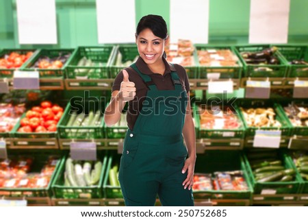 Young Female Sales Clerk Showing Thumb Up Gesture In Supermarket