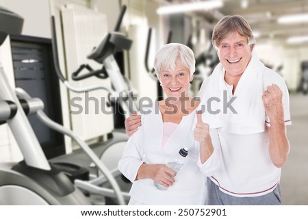 Portrait Of Happy Senior Couple Showing Thumb Up Gesture At Fitness Gym