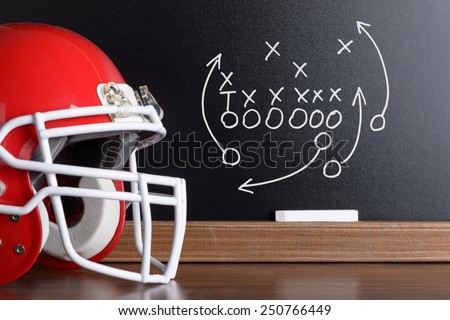 Sport Helmet In Front Of A Chalkboard With Football Play Strategy