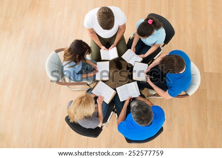 High Angle View Of People Reading Bible Together