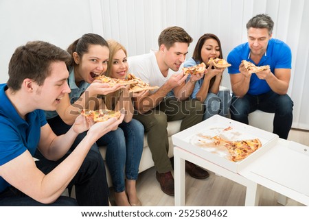 Group Of Multiethnic Friends Eating Pizza Together