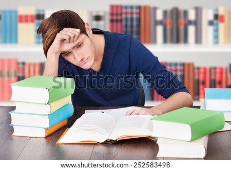 Portrait Of A Tired Young Man Studying In Library