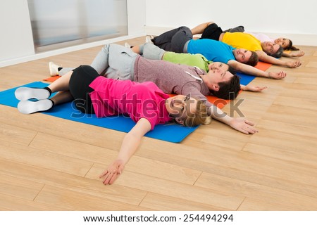 Multiethnic Group Of Happy People Exercising On Mat At Gym