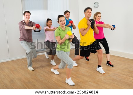 Multiethnic Group Of People Exercising With Kettle Bell Over White Background