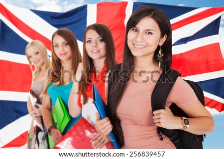 Group Of Happy College Students Standing In Front Of British Flag