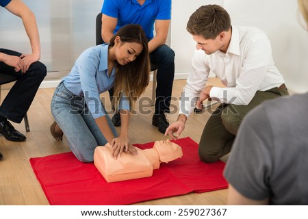 Instructor Demonstrating Cpr Chest Compression On A Dummy