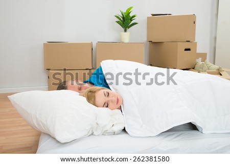Young Couple Sleeping On Mattress In New Home