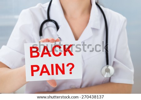 Close-up Of Female Doctor Holding Placard With Text Back Pain