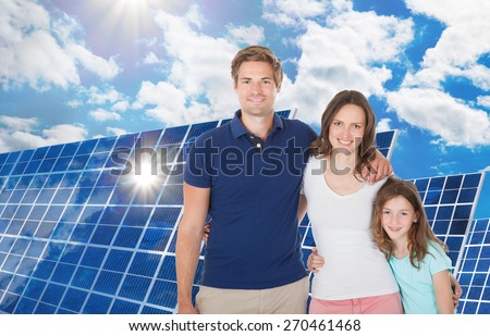 Happy Family Standing Near The Large Solar Panel