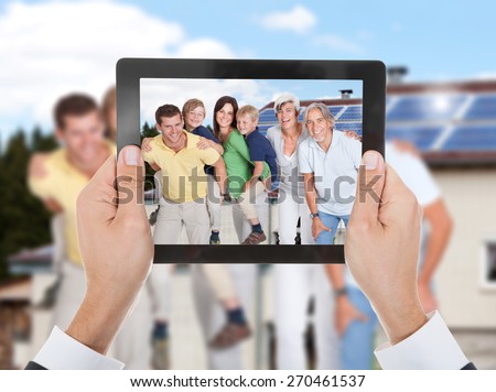Close-up Of Hand Taking Photo Of Two Generation Family With Digital Tablet