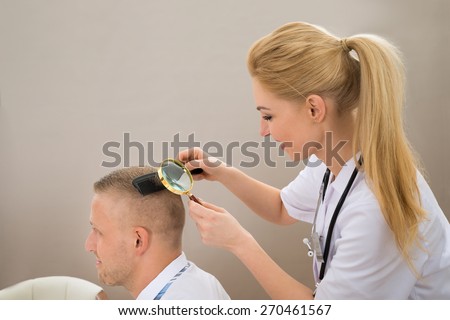 Close-up Female Dermatologist Looking At Patient\'s Hair Through Magnifying Glass