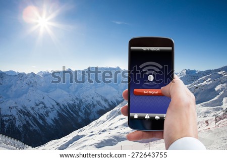 Close-up Of Person Hand With No Wifi Signal On Mobile Phone In Snowy Mountain