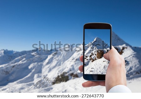 Close-up Of Person Hand Photographing Snowy Mountain Landscape