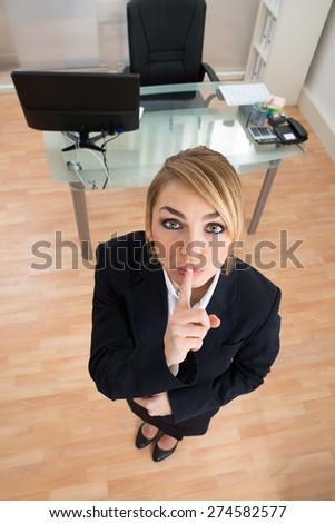 High Angle View Of Young Businesswoman With Finger On Lips
