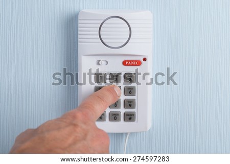 Close-up Of A Hand Pushing Button In Security System
