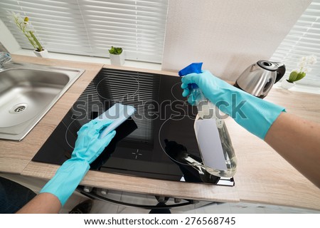 Person Hands In Blue Glove Cleaning Induction Stove