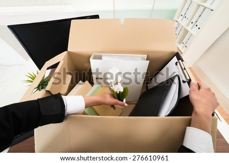 High Angle View Of Businesswoman Packing Personal Belonging In Box