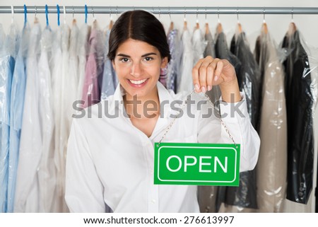 Young Happy Female Store Owner Holding Open Sign Board