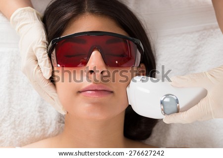 Close-up Of Beautician Giving Epilation Laser Treatment On Woman\'s Face