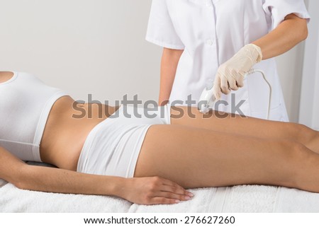 Woman Receiving Epilation Laser Treatment On Thigh At Beauty Clinic